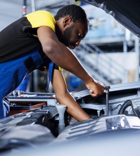mechanic fixes car fuel tank in garage